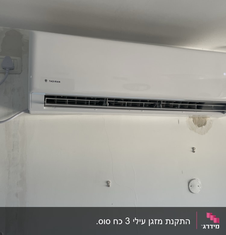 מזגן מותקן על קיר עם חיבור לחשמל